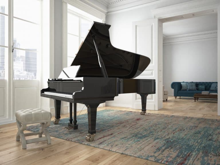 Black piano with a white bench in a living room