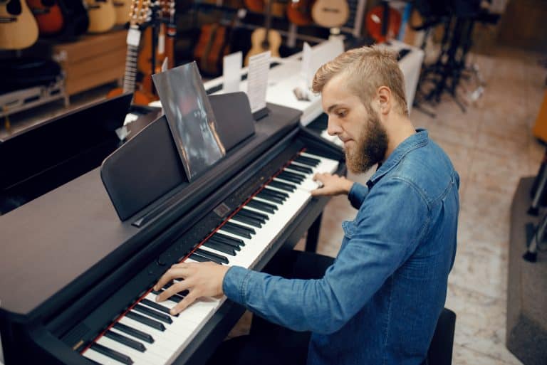 Man plays digital piano in a music store