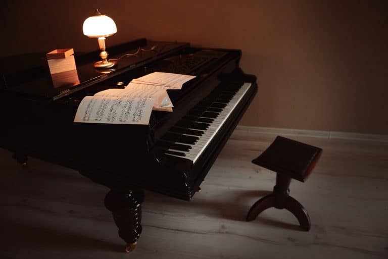 Piano lamp on top of an old classical piano